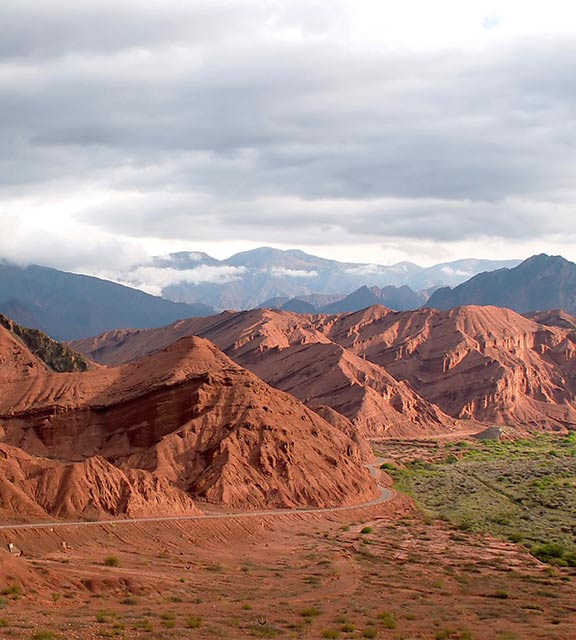 A road hugs the side of mountains made of red rock near the northern Argentinian city of Salta.